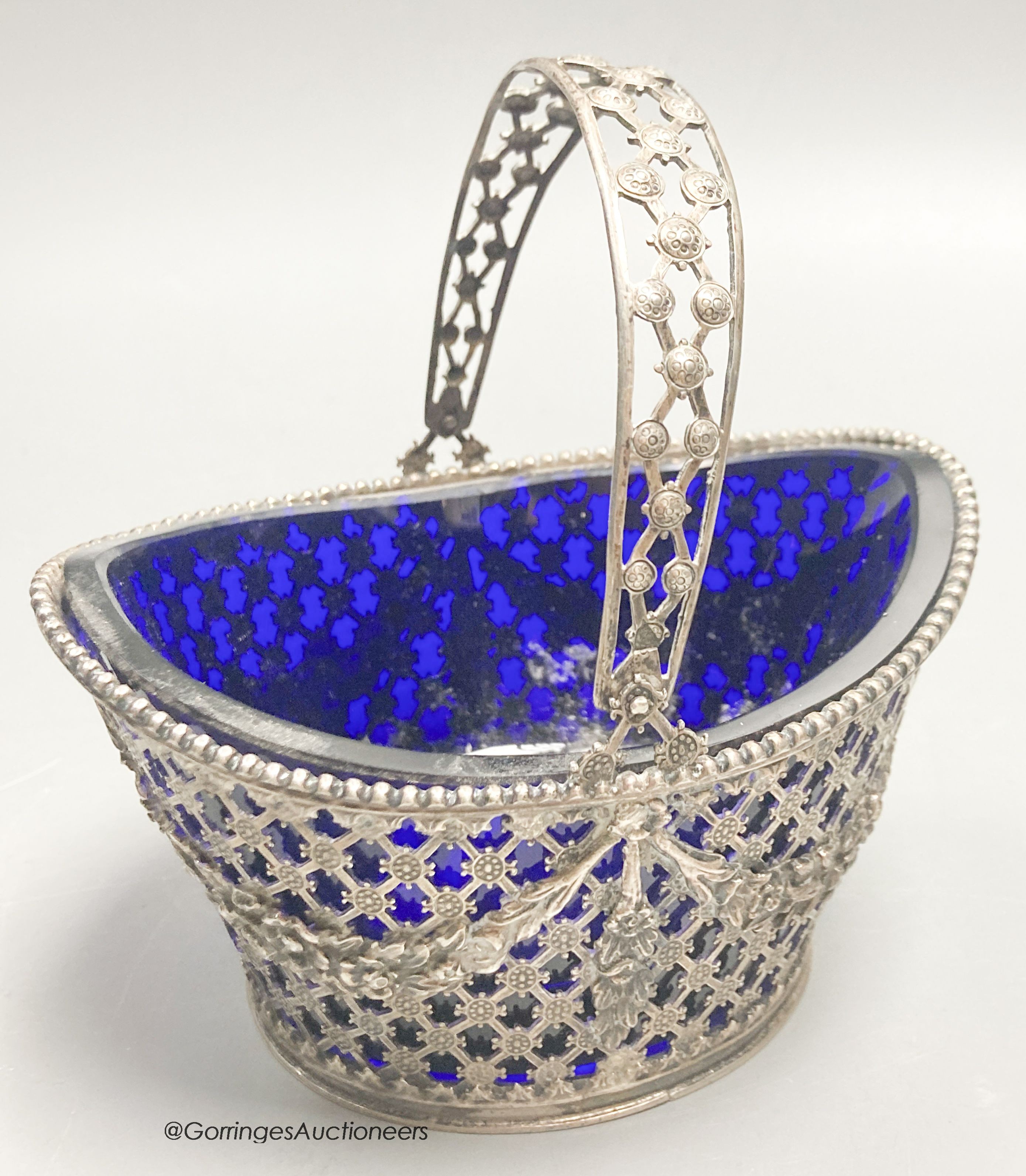 A 19th century Dutch pierced white metal boat shaped sugar basket, with blue glass liner, length 11.5cm